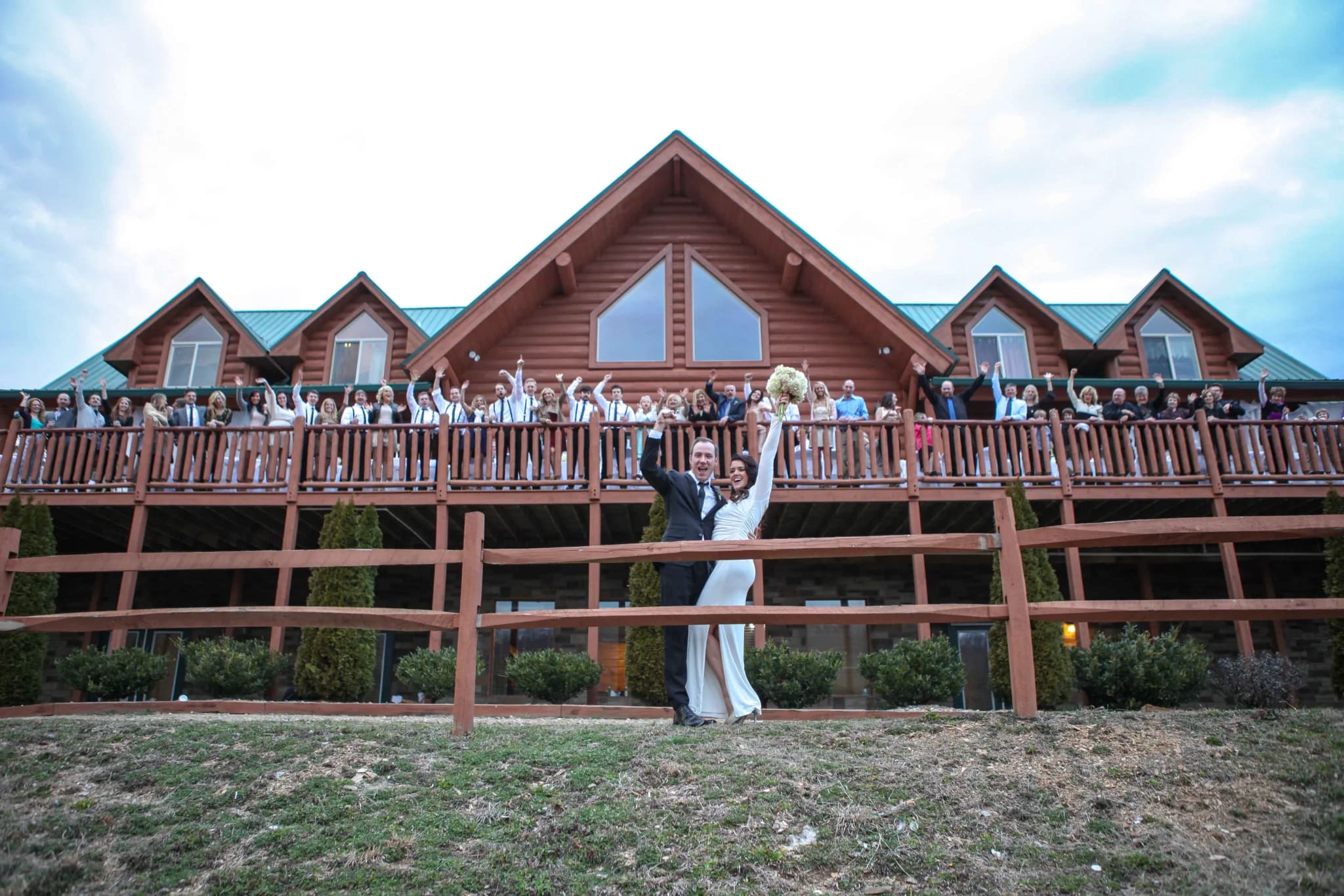 Wedding couple celebrating outside large log cabin wedding venue near Dollywood at Moose Hollow Lodge in Pigeon Forge