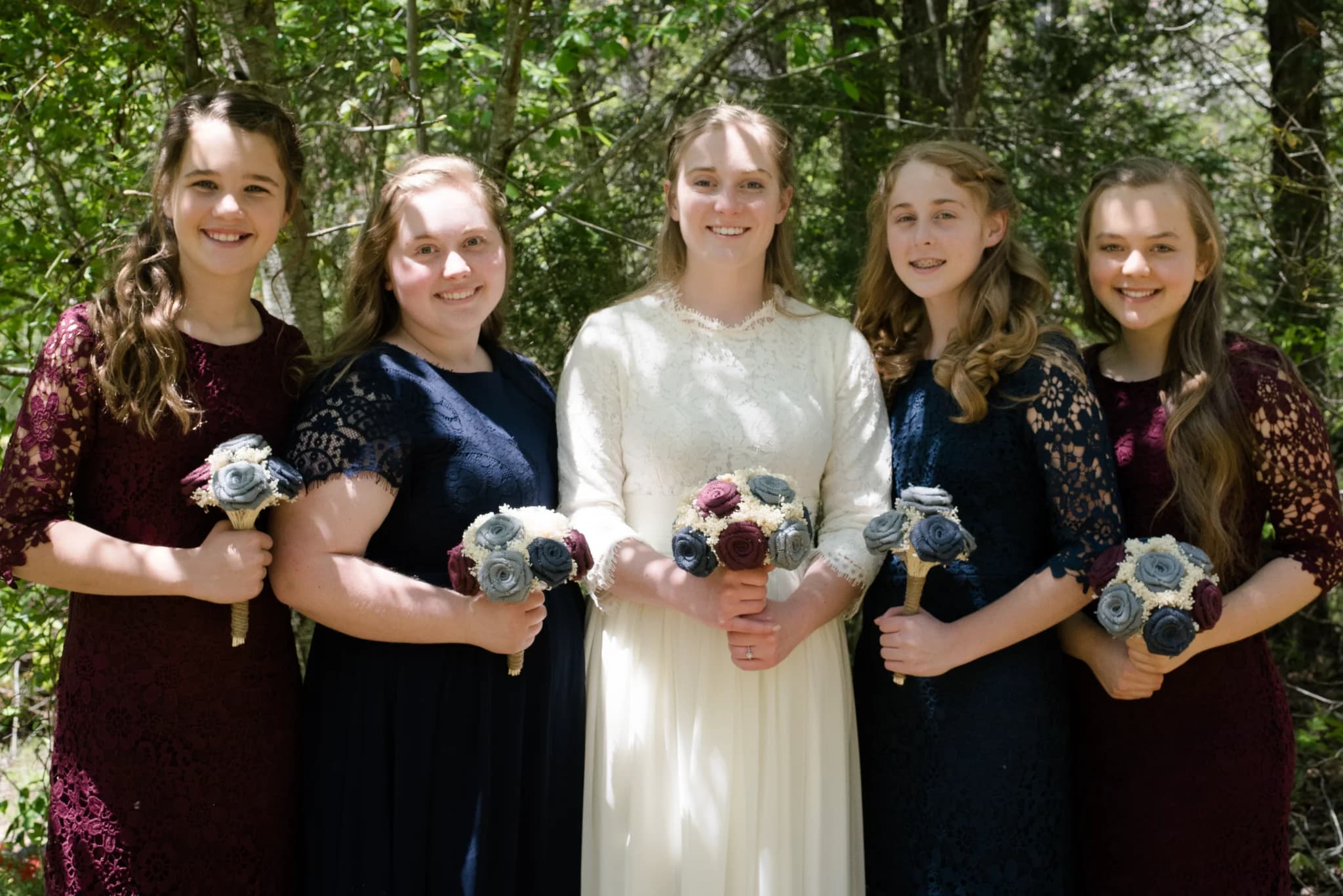 Bride and bridesmaids with bouquets in the woods at Moose Hollow Lodge in Pigeon Forge near Dollywood and Smoky Mountains