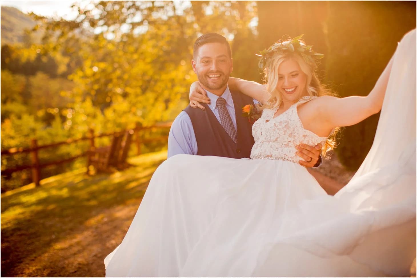 Groom carrying bride at sunset outdoor wedding near the Smoky Mountains at Moose Hollow Lodge in Pigeon Forge
