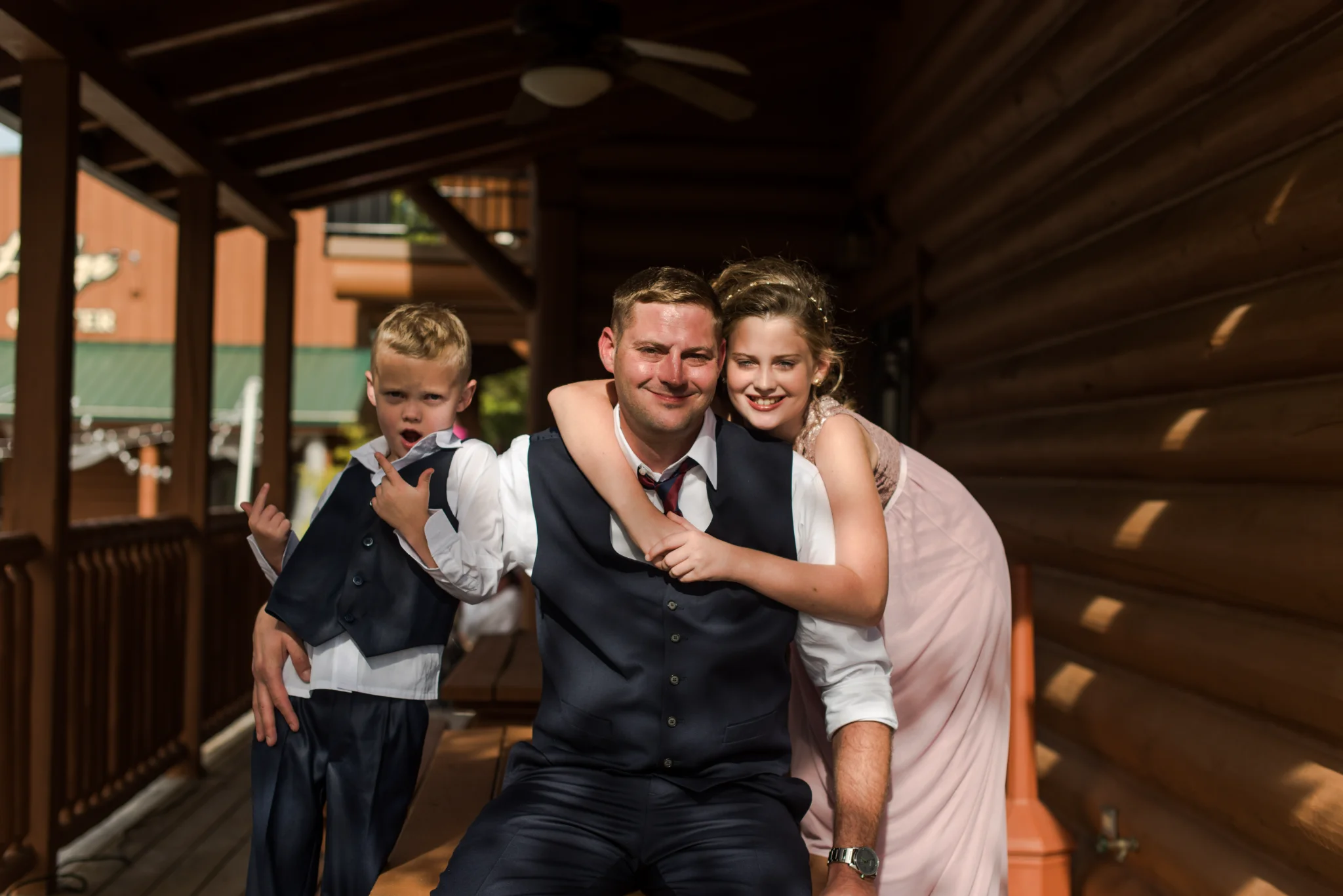 Wedding guests posing on a rustic log cabin deck at Moose Hollow Lodge in Pigeon Forge near the Smoky Mountains