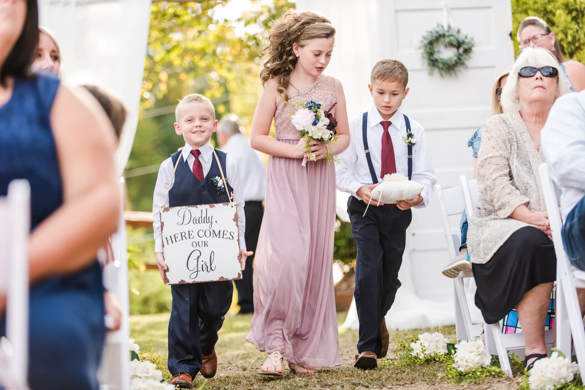 Children walking down outdoor wedding aisle with sign at Moose Hollow Lodge in Pigeon Forge near Smoky Mountains