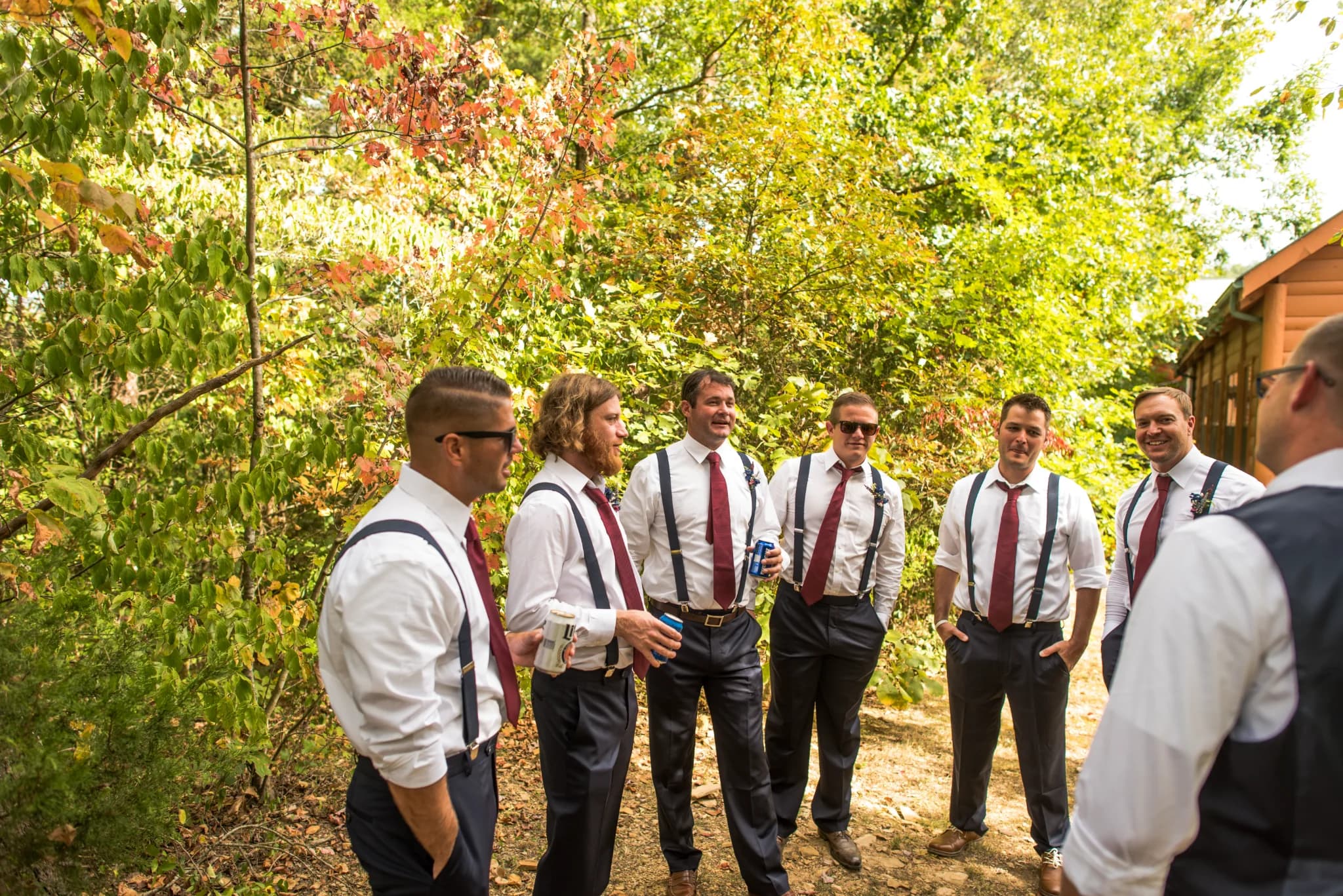 Groomsmen in red ties and suspenders in a forest setting at Moose Hollow Lodge in Pigeon Forge near Smoky Mountains