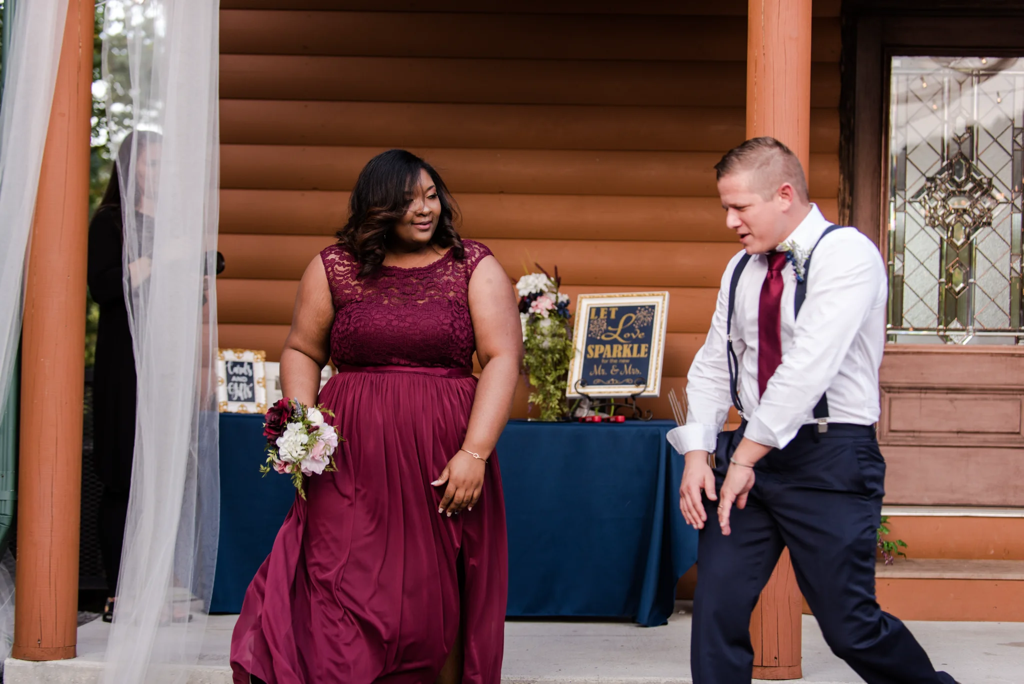 Bridesmaid and groomsman dancing on rustic cabin porch at Moose Hollow Lodge in Pigeon Forge near Smoky Mountains