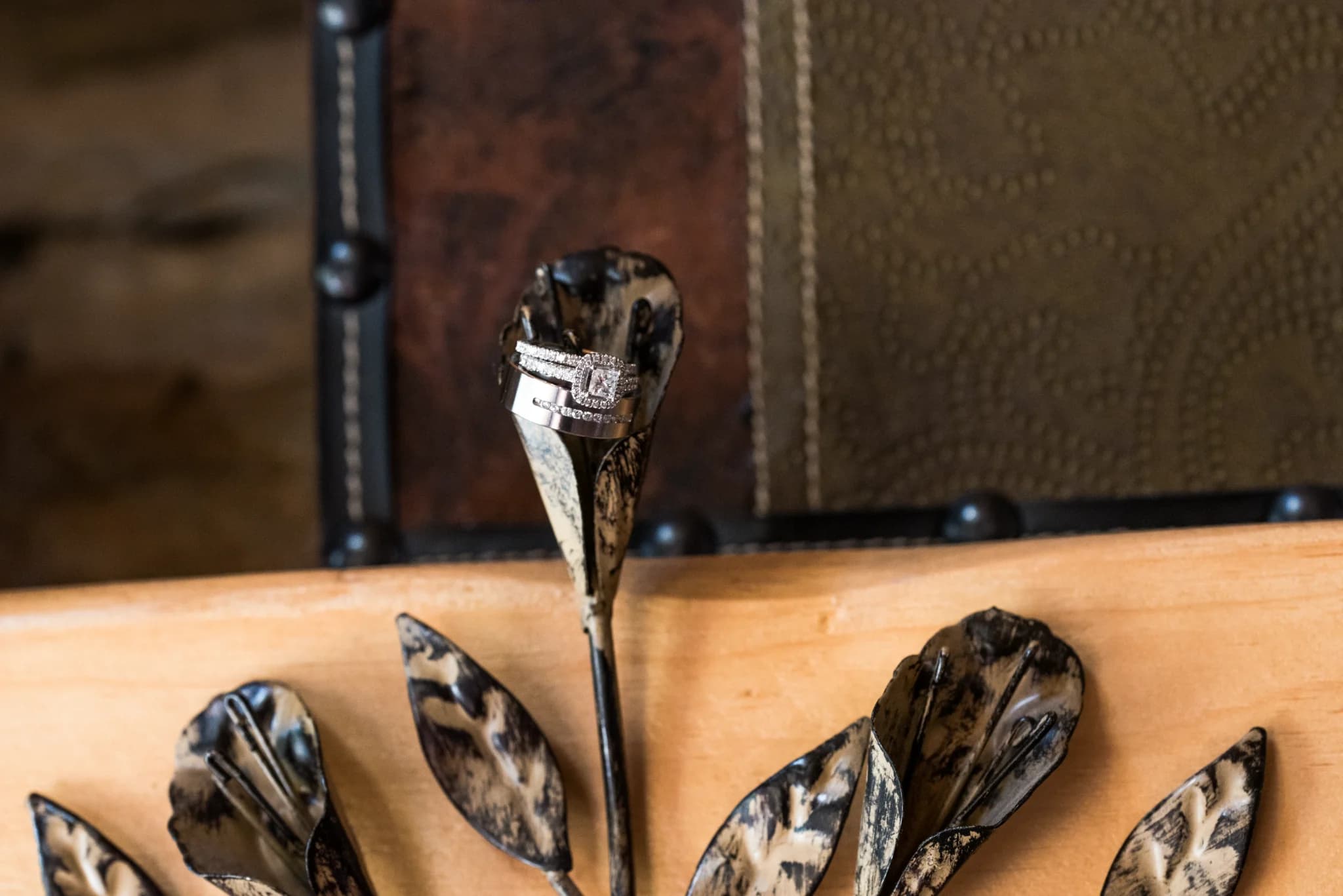 Diamond wedding rings on rustic metal floral decor at Moose Hollow Lodge in Pigeon Forge
