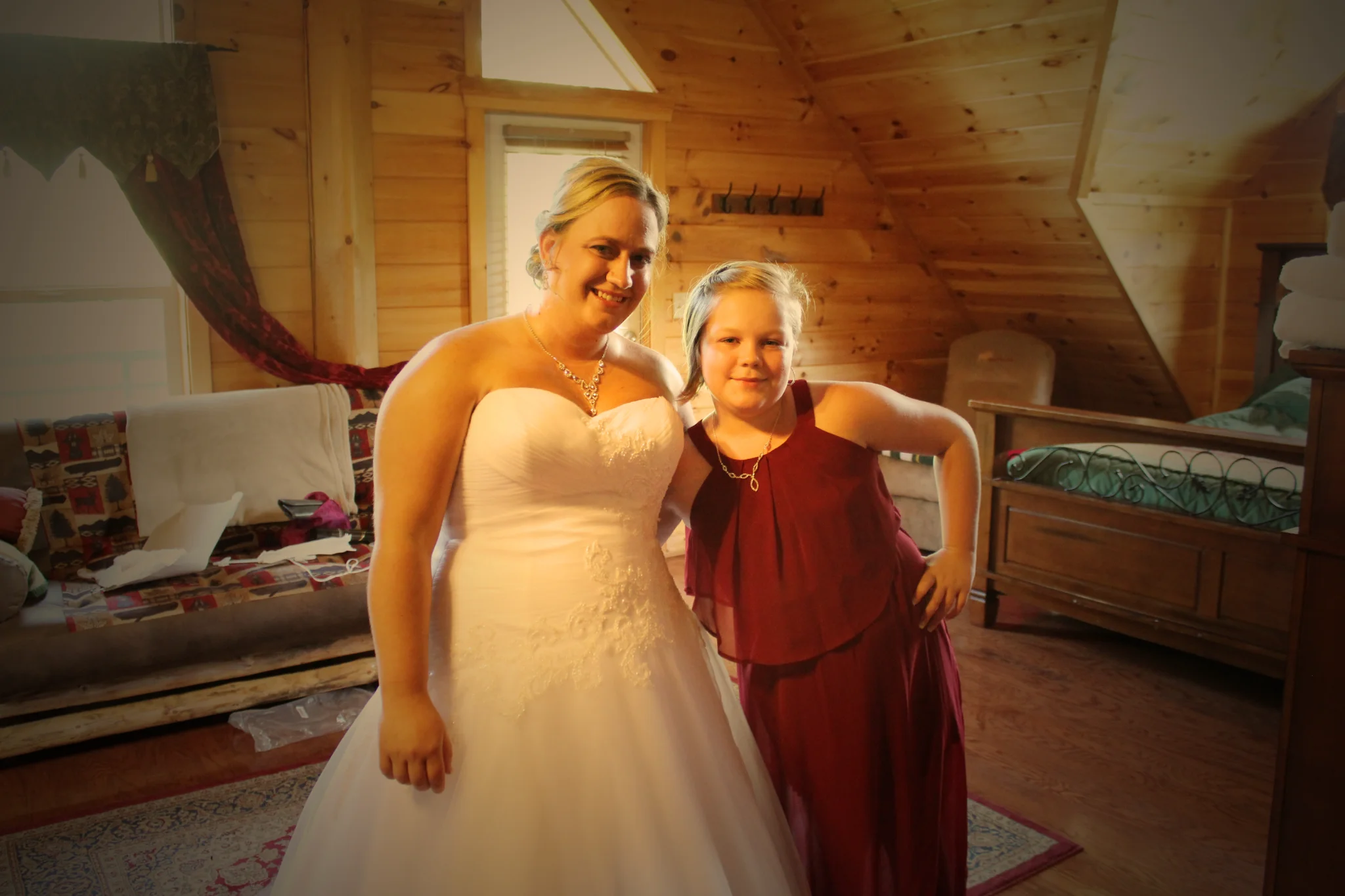Bride and flower girl in a rustic wood-paneled bedroom at Moose Hollow Lodge in Pigeon Forge