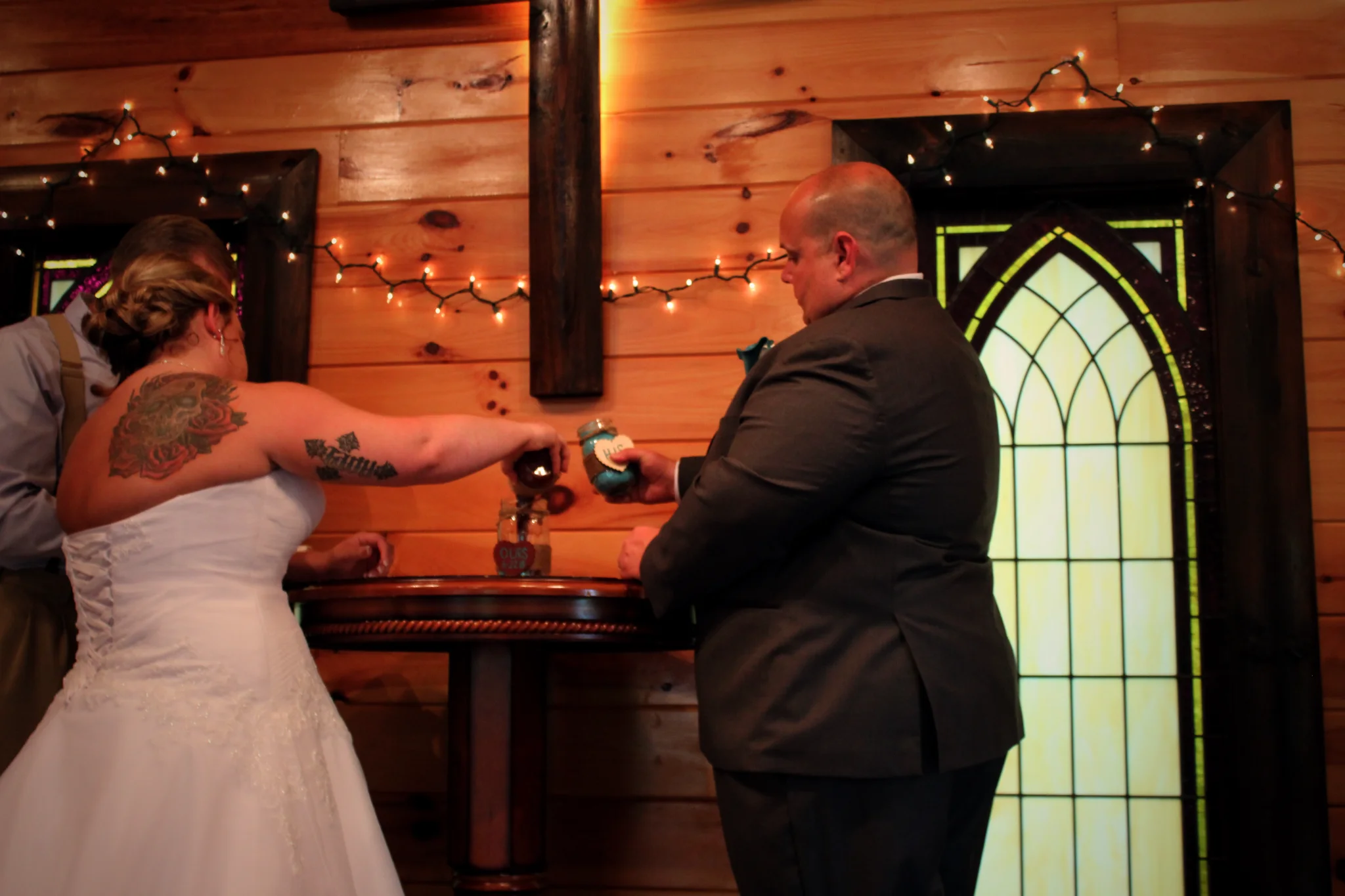 Bride and groom performing sand ceremony in rustic wedding chapel at Moose Hollow Lodge in Pigeon Forge