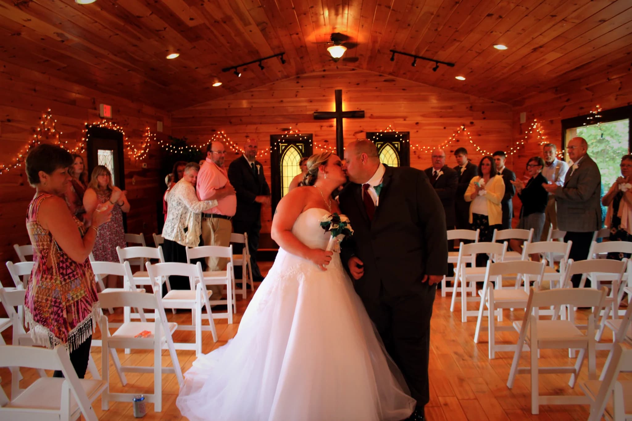 Bride and groom kissing in a rustic wood-paneled wedding chapel at Moose Hollow Lodge in Pigeon Forge