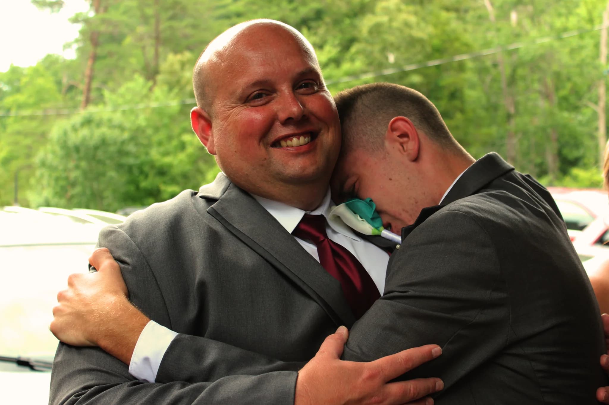 Emotional wedding hug outdoors with lush forest views at Moose Hollow Lodge near Smoky Mountains in Pigeon Forge