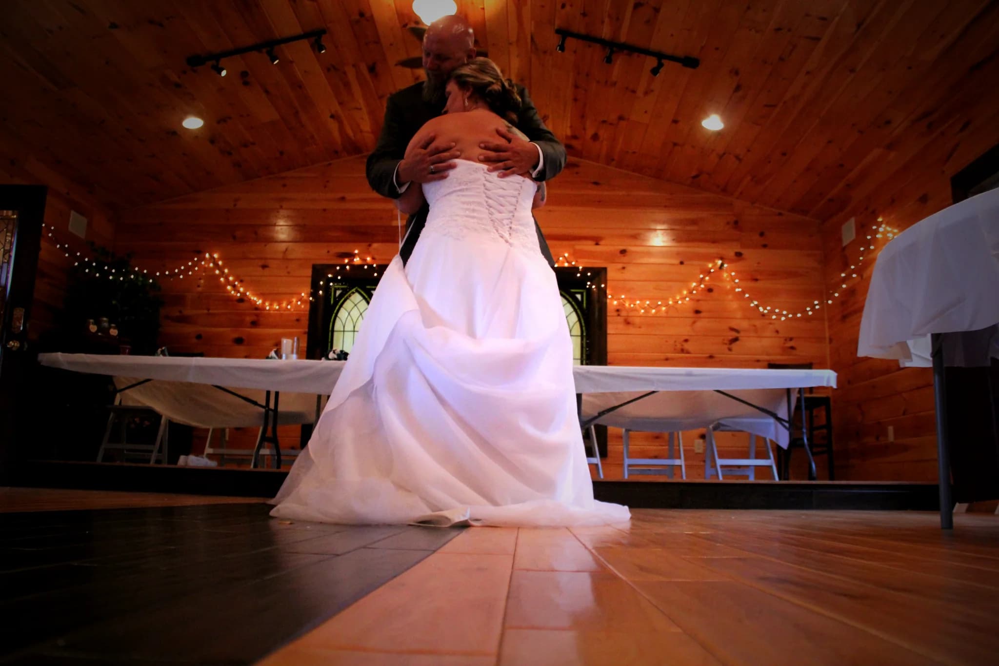 Wedding couple dancing in a rustic wood-paneled reception hall at Moose Hollow Lodge in Pigeon Forge