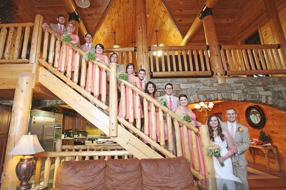 Wedding party on a grand log staircase in a rustic lodge at Moose Hollow Lodge in Pigeon Forge