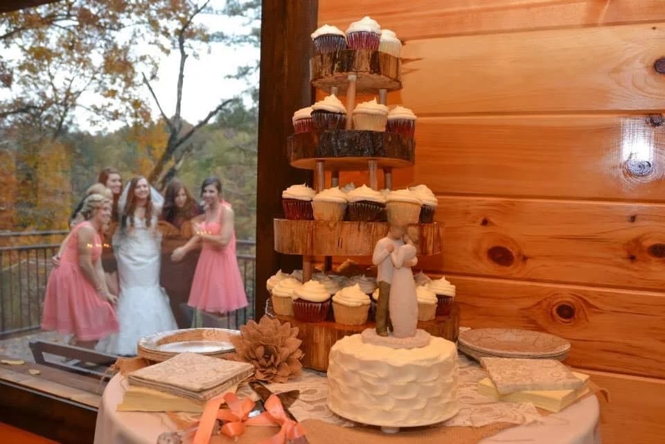 Rustic tiered cupcake tower and wedding cake in reception area at Moose Hollow Lodge in Pigeon Forge