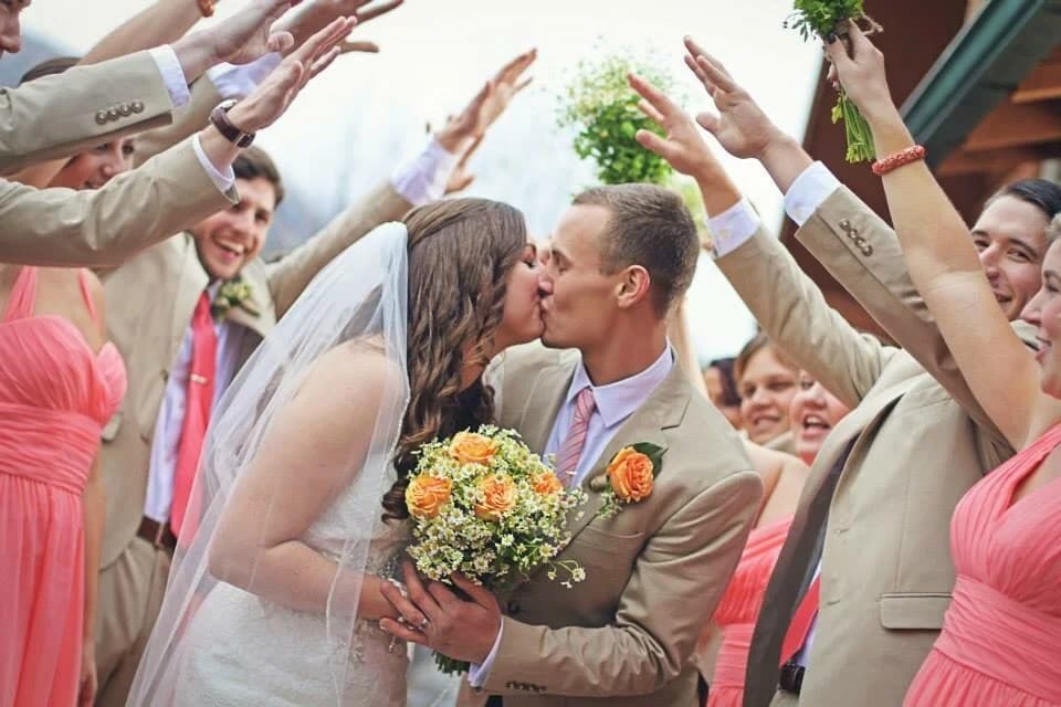 Wedding couple kissing under a canopy of hands at Moose Hollow Lodge in Pigeon Forge near the Smoky Mountains