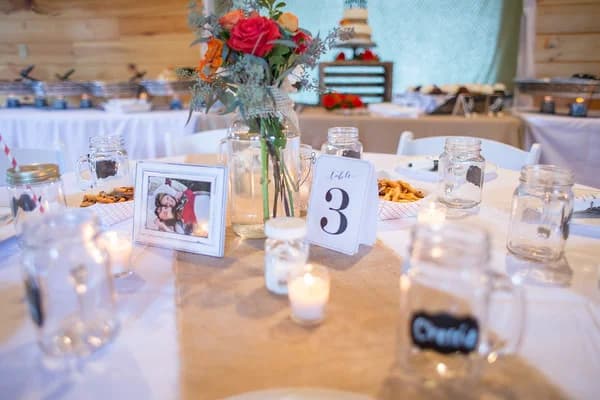 Rustic wedding reception table with floral centerpiece and mason jars at Moose Hollow Lodge in Pigeon Forge