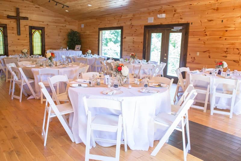 Rustic wedding reception hall with white linens and round tables at Moose Hollow Lodge in Pigeon Forge