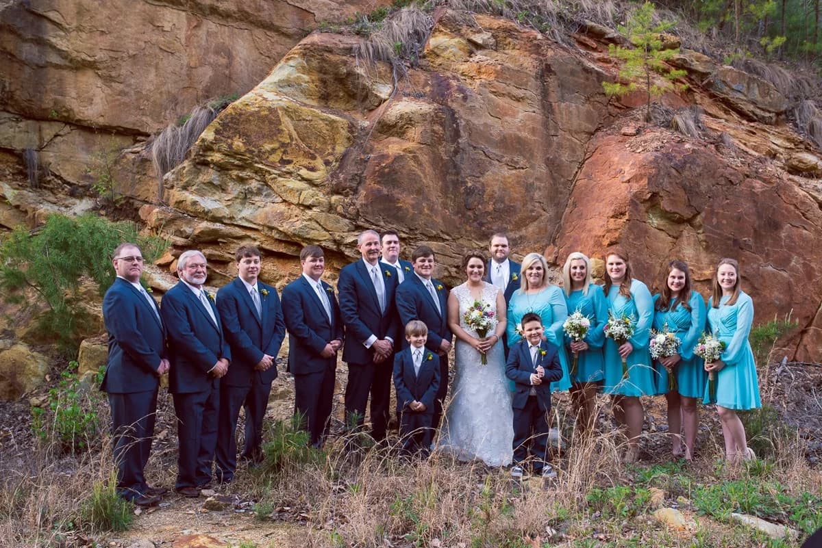 Wedding party posing in front of a rock cliff at Moose Hollow Lodge in Pigeon Forge near the Smoky Mountains