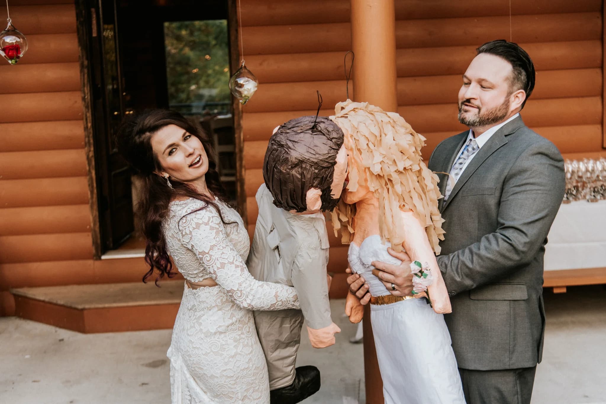 Bride and groom with kissing piñatas on log cabin patio at Moose Hollow Lodge in Pigeon Forge near Smoky Mountains.