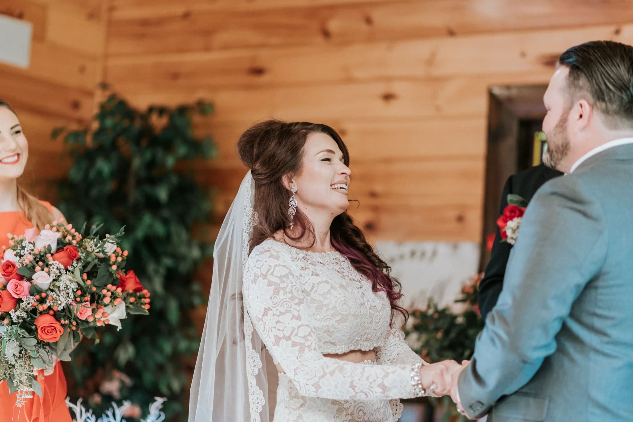 Bride and groom at rustic indoor wedding ceremony with wood walls at Moose Hollow Lodge in Pigeon Forge