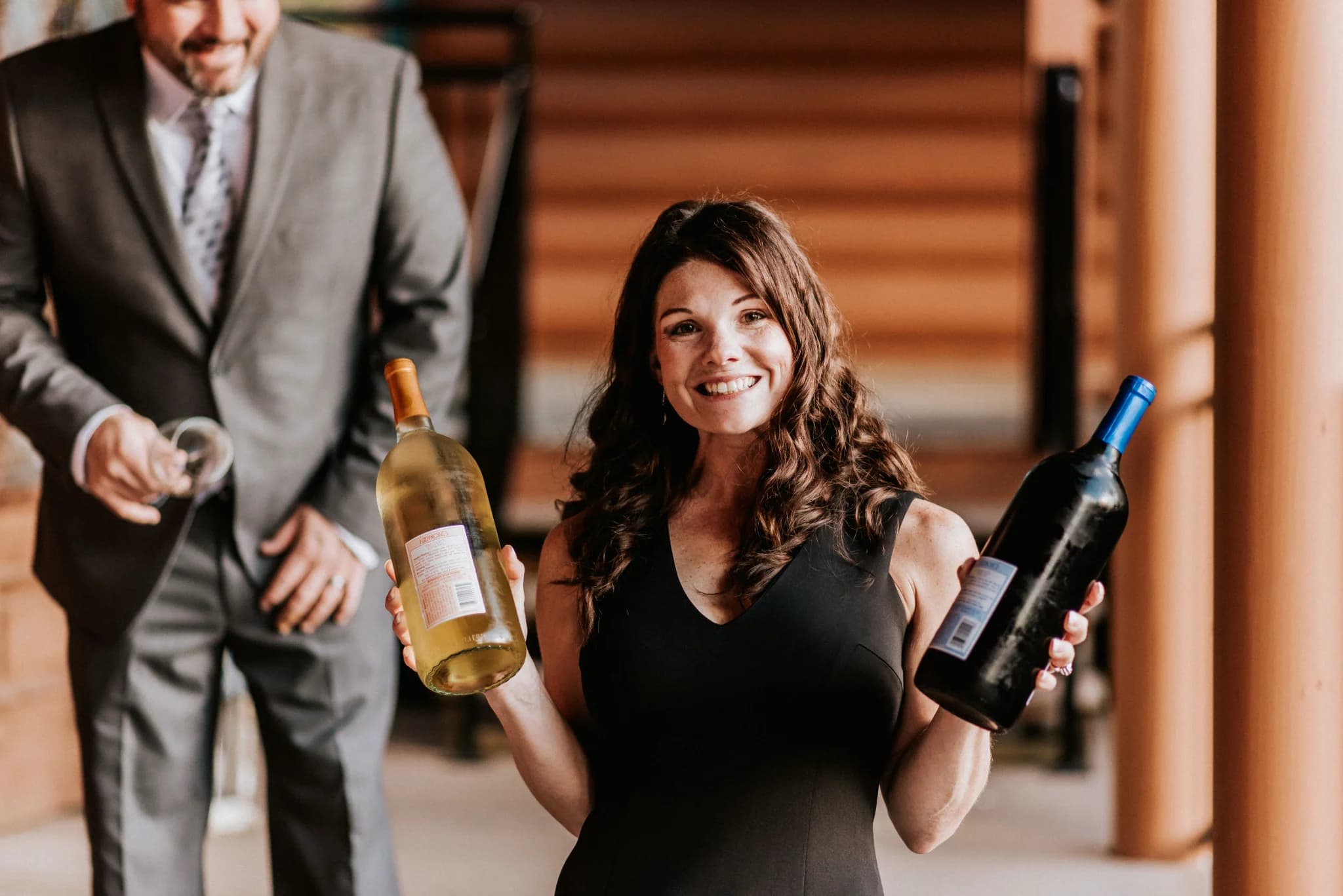 Smiling woman holding wine bottles on a lodge deck at Moose Hollow Lodge in Pigeon Forge near Smoky Mountains
