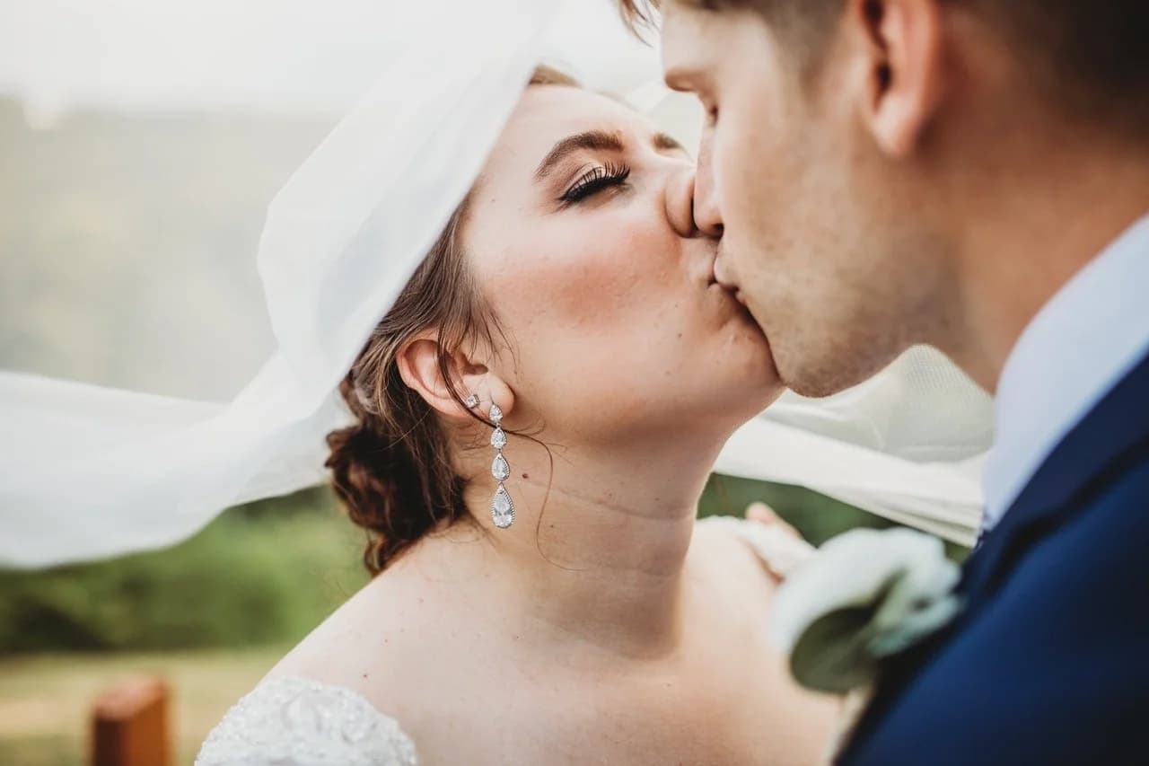 Bride and groom kissing under a white veil at Moose Hollow Lodge in Pigeon Forge near the Smoky Mountains