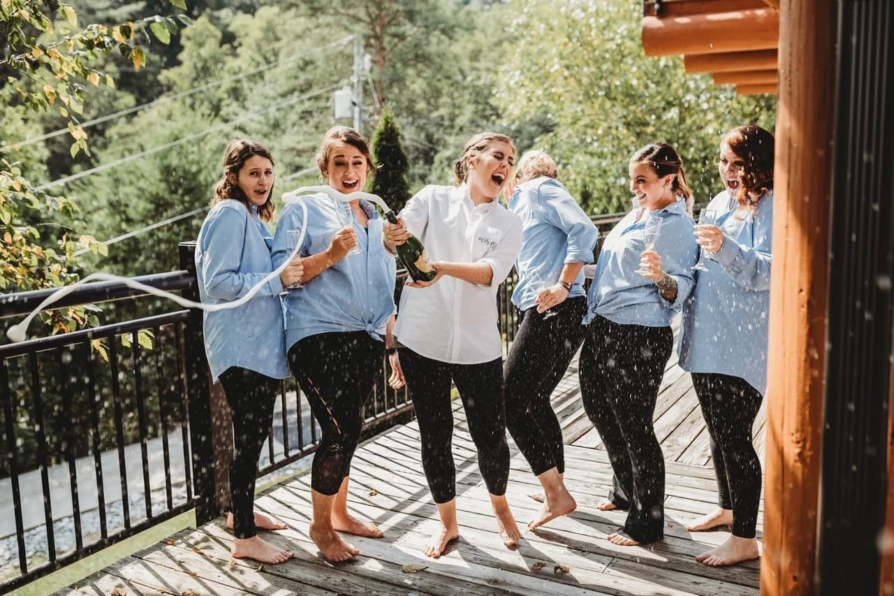 Bridesmaids popping champagne on a scenic deck near the Smoky Mountains at Moose Hollow Lodge in Pigeon Forge