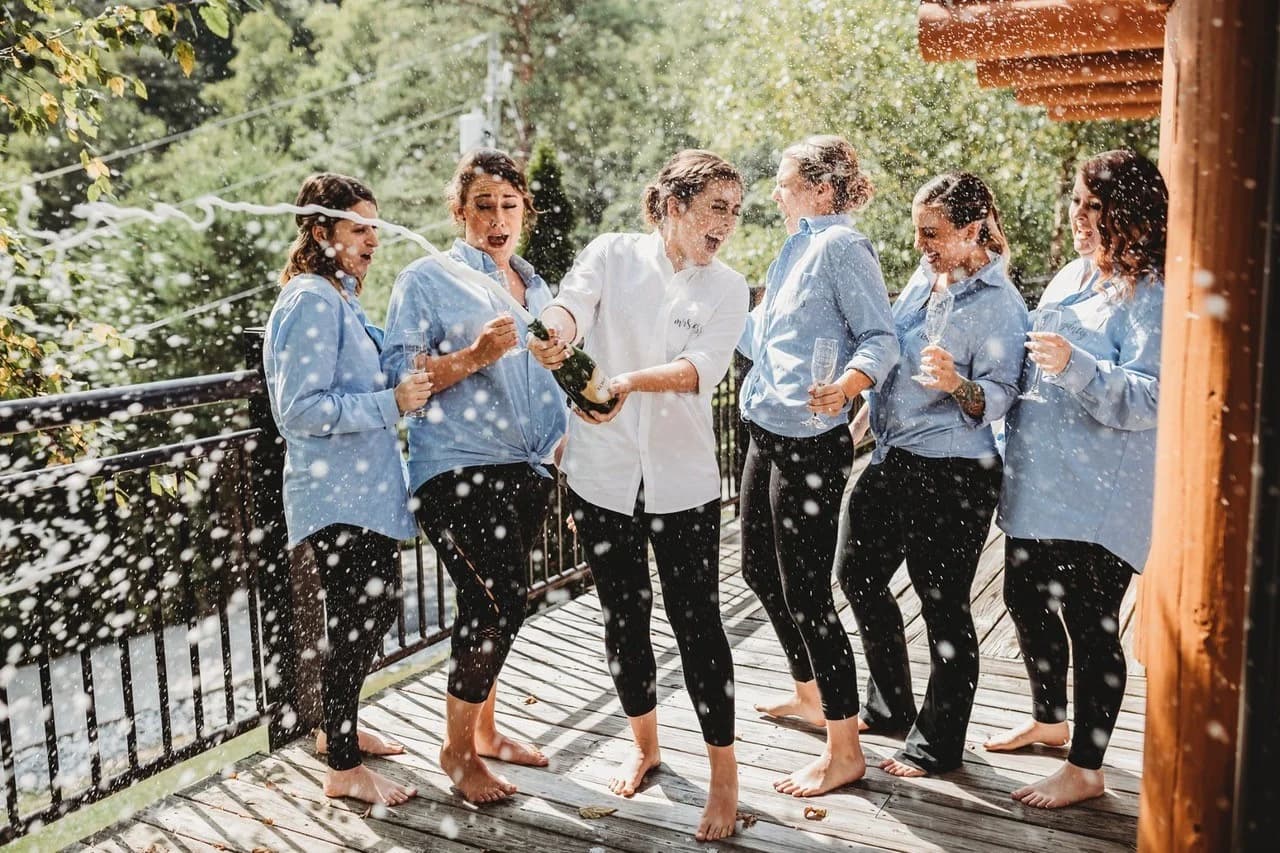 Bridesmaids spraying champagne on an outdoor deck at Moose Hollow Lodge in Pigeon Forge near the Smoky Mountains