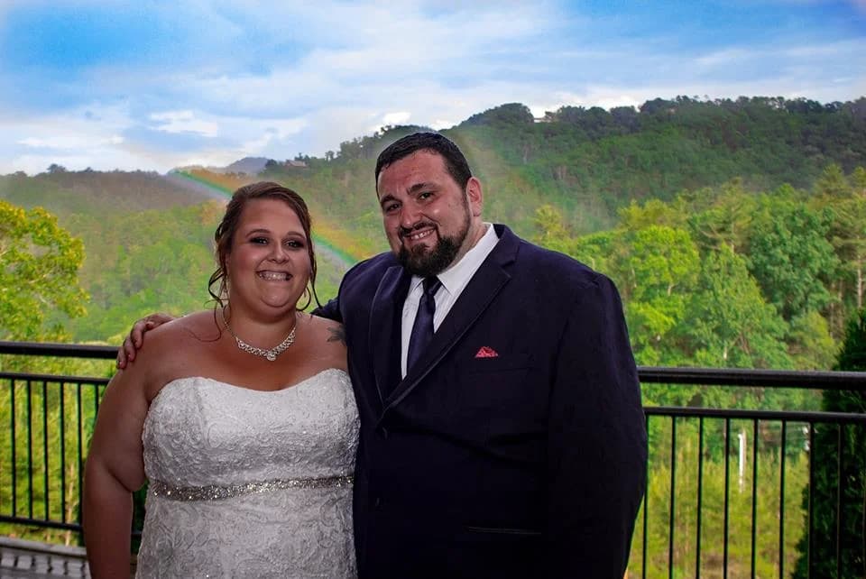 Bride and groom on a deck with rainbow and Smoky Mountains views at Moose Hollow Lodge in Pigeon Forge near Dollywood