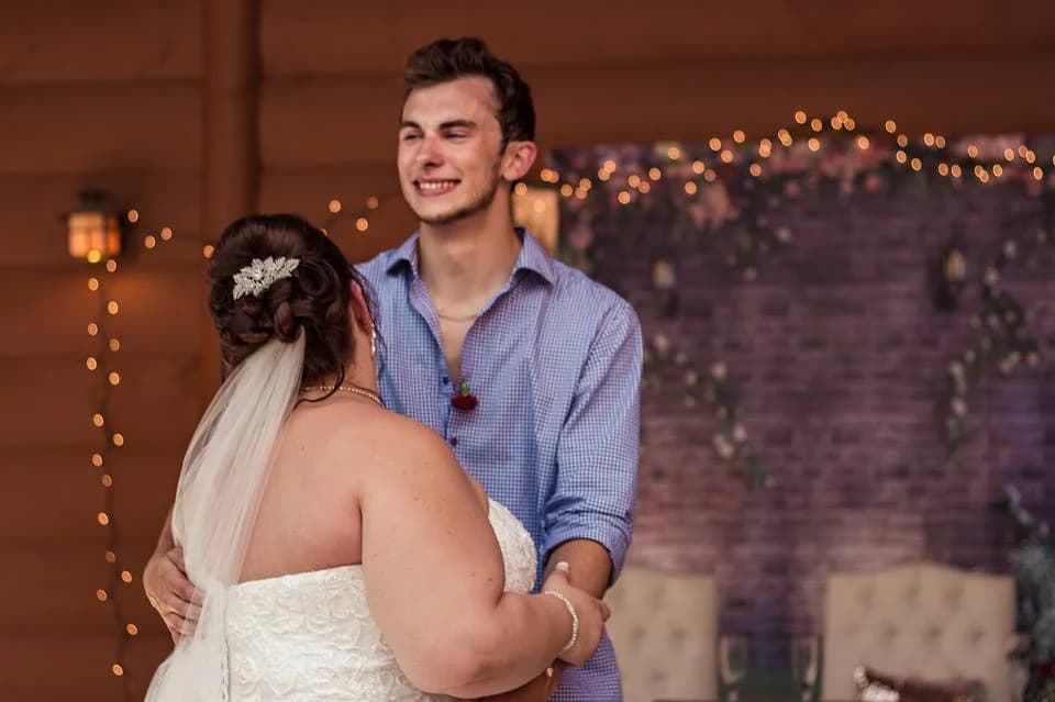 Bride and groom dancing at a rustic wedding reception with string lights at Moose Hollow Lodge in Pigeon Forge