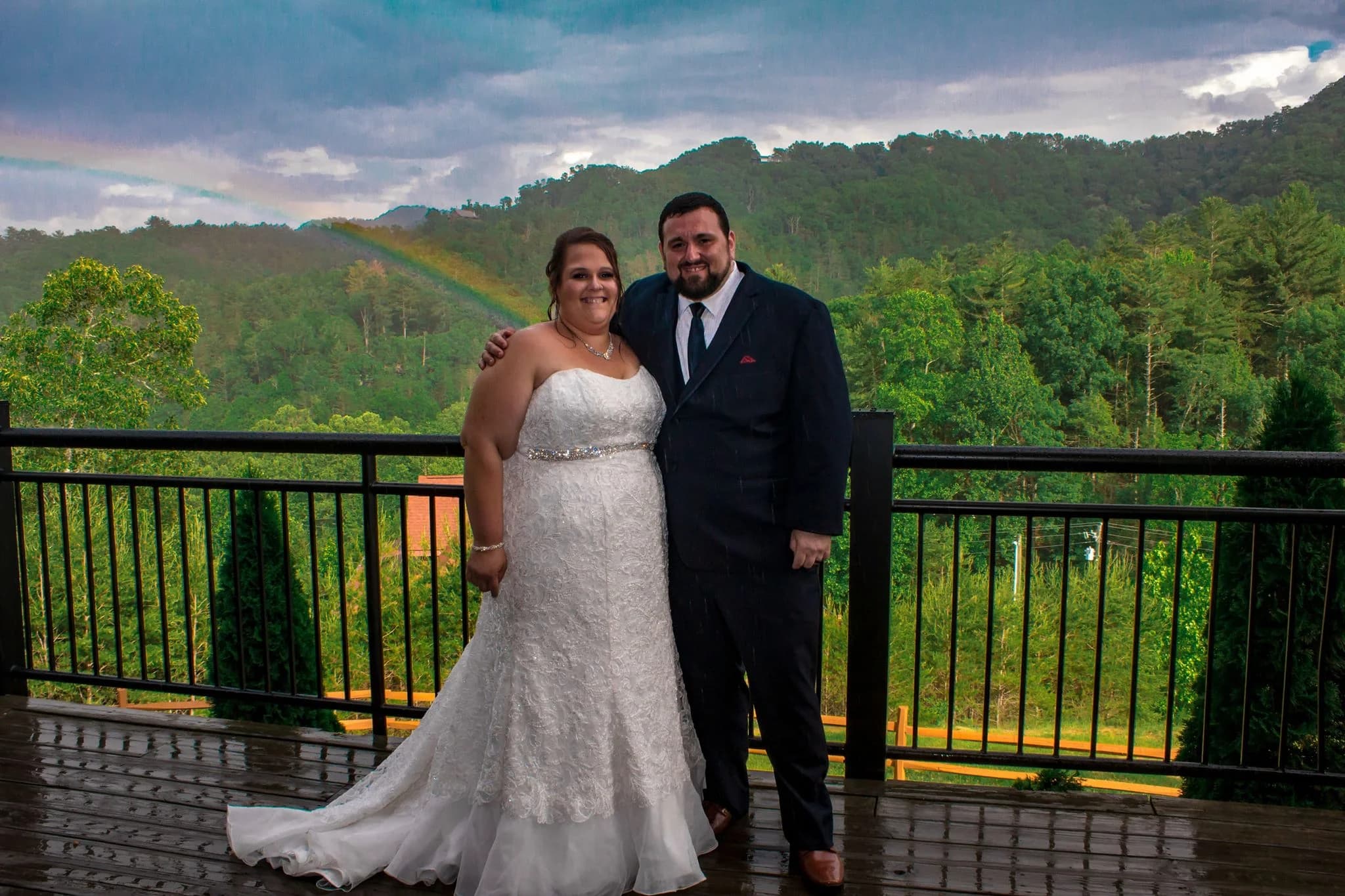 Wedding couple on a deck with a rainbow over Smoky Mountains near Dollywood at Moose Hollow Lodge in Pigeon Forge