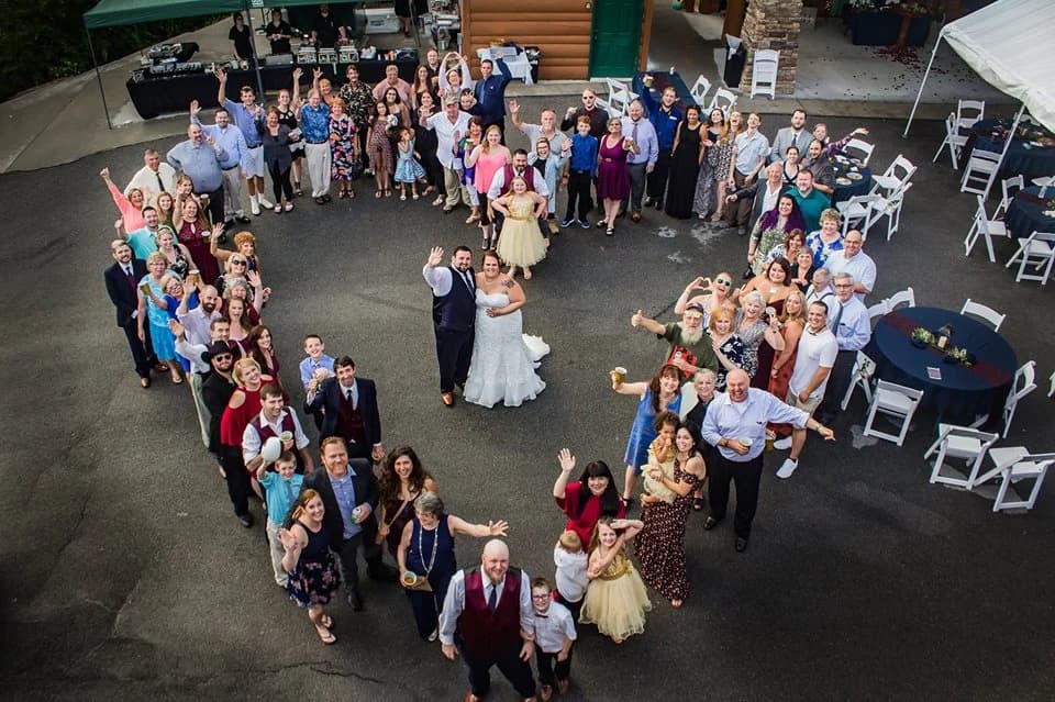 Large wedding group in heart shape at outdoor reception near Dollywood at Moose Hollow Lodge in Pigeon Forge