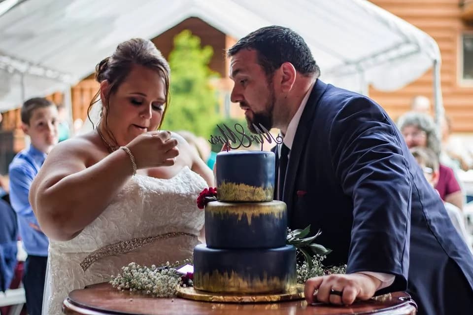 Bride and groom with navy wedding cake under a tent at Moose Hollow Lodge in Pigeon Forge near Dollywood