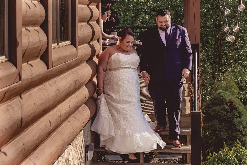 Bride and groom walking down log cabin stairs at Moose Hollow Lodge in Pigeon Forge near the Smoky Mountains