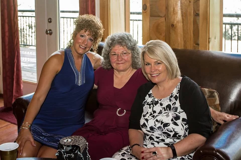 Wedding guests on a leather sofa in a rustic log cabin room at Moose Hollow Lodge in Pigeon Forge