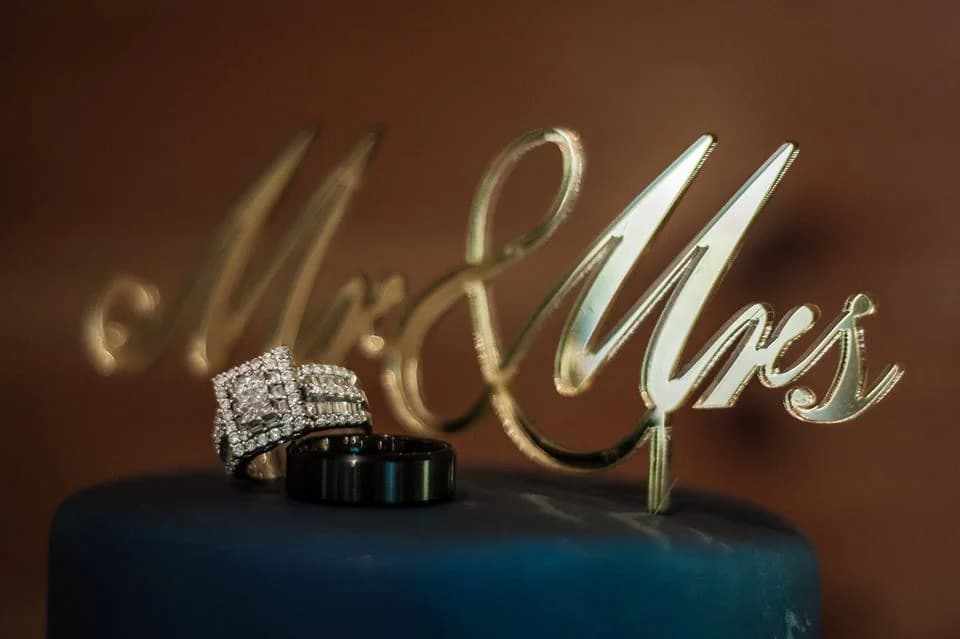 Diamond wedding rings and gold Mr & Mrs topper on a blue cake at Moose Hollow Lodge in Pigeon Forge