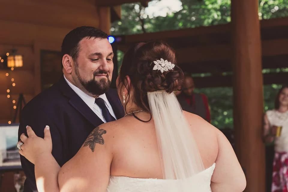 Bride and groom dancing in a rustic log pavilion at Moose Hollow Lodge in Pigeon Forge near the Smoky Mountains.