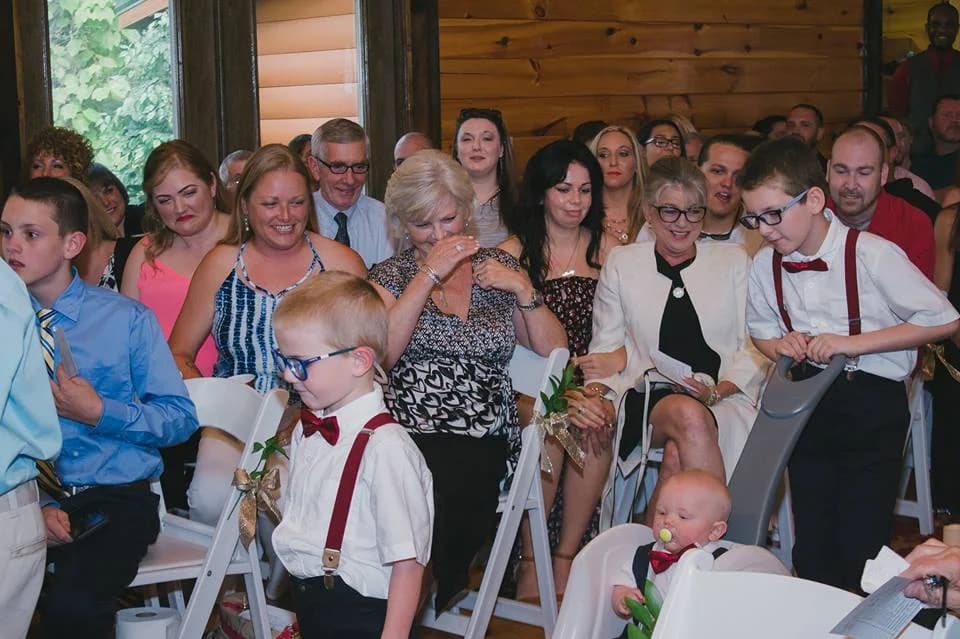 Wedding guests seated in a rustic wood-paneled ceremony room at Moose Hollow Lodge in Pigeon Forge