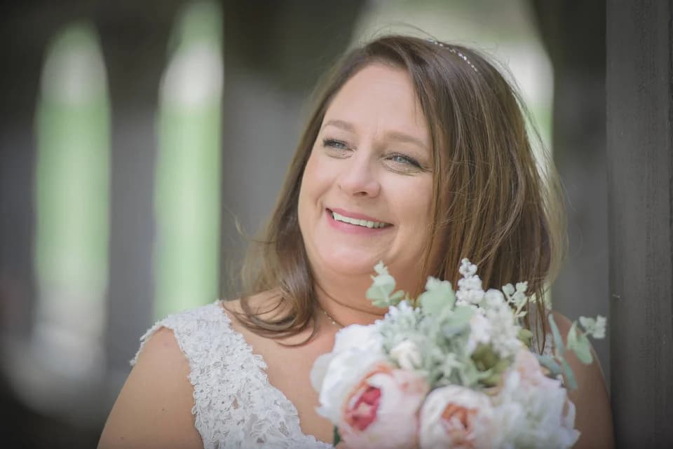 Smiling bride holding floral bouquet near the Smoky Mountains at Moose Hollow Lodge in Pigeon Forge