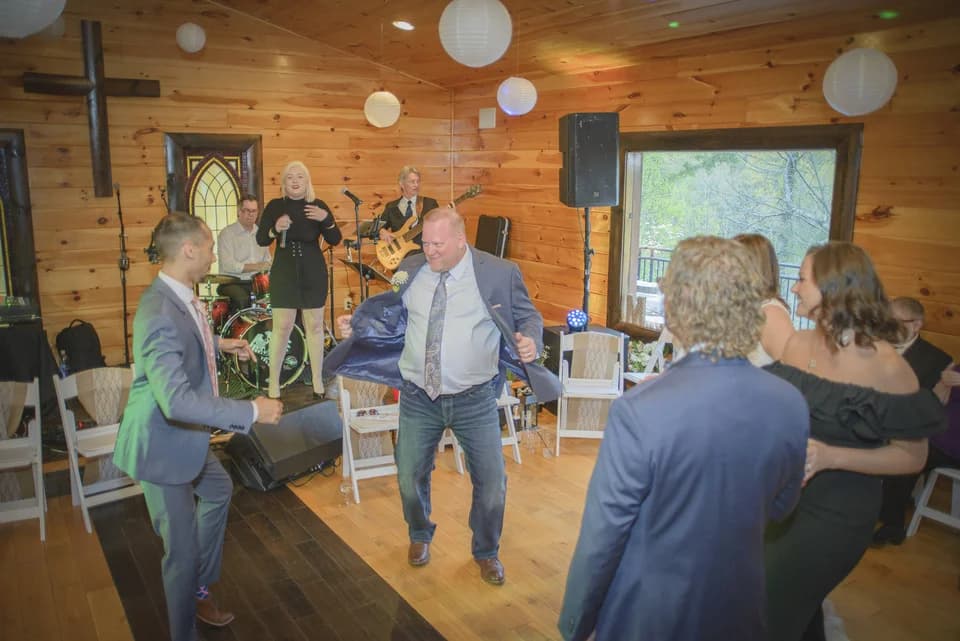 Wedding guests dancing in rustic chapel with live band at Moose Hollow Lodge in Pigeon Forge
