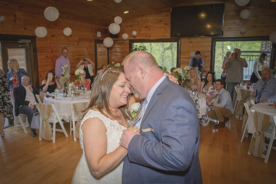 Wedding first dance in a rustic reception hall with paper lanterns at Moose Hollow Lodge in Pigeon Forge