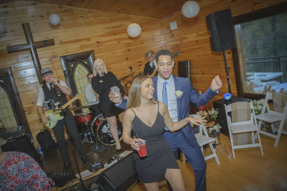 Guests dancing to live band in rustic wood-paneled reception space at Moose Hollow Lodge in Pigeon Forge
