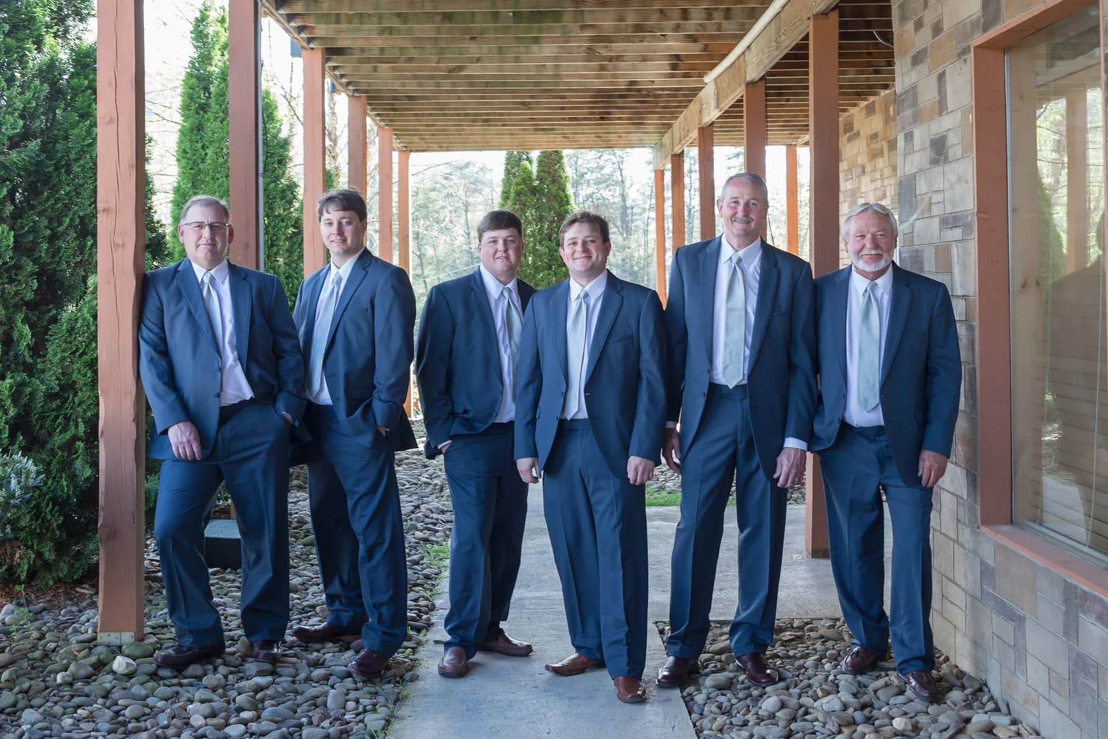 Groomsmen in blue suits on covered stone walkway at Moose Hollow Lodge in Pigeon Forge near Smoky Mountains