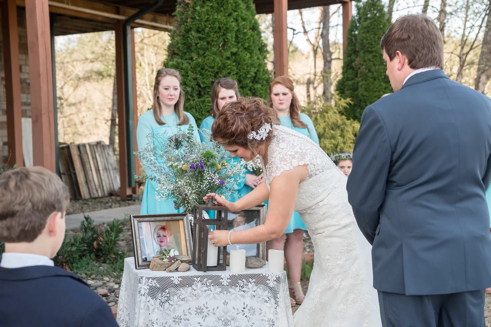 Bride lighting memorial candle during outdoor ceremony near Smoky Mountains at Moose Hollow Lodge in Pigeon Forge