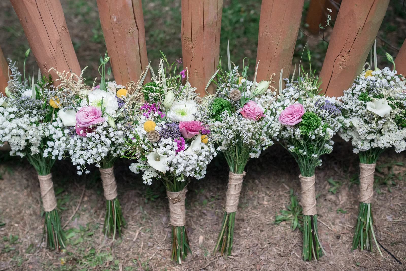 Rustic floral wedding bouquets by a log fence near Dollywood at Moose Hollow Lodge in Pigeon Forge