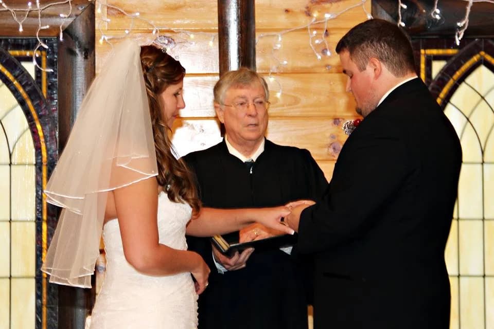 Bride and groom exchanging rings in rustic wedding chapel at Moose Hollow Lodge in Pigeon Forge