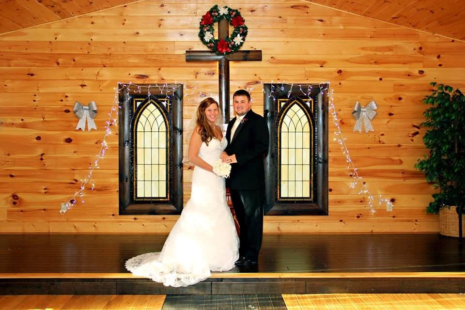 Bride and groom in rustic wood wedding chapel with stained glass at Moose Hollow Lodge in Pigeon Forge