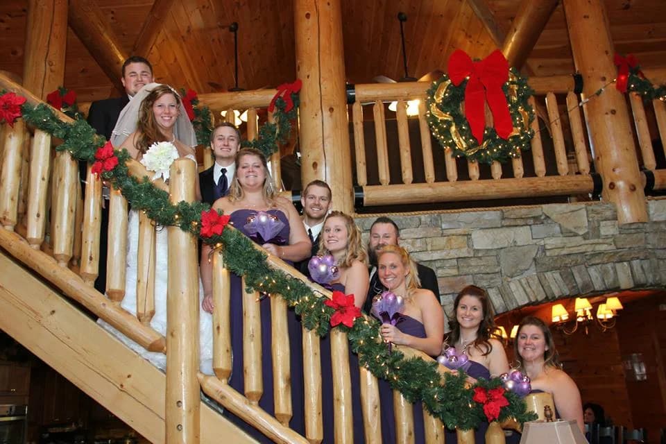 Large wedding party on a rustic log staircase with holiday decor at Moose Hollow Lodge in Pigeon Forge