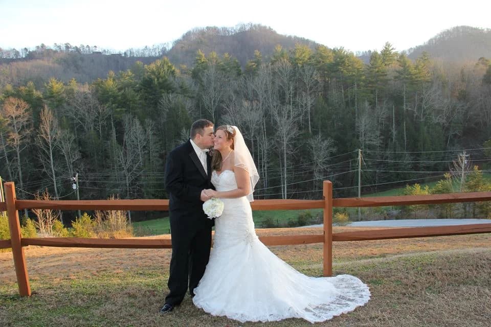 Wedding couple by a wooden fence with Smoky Mountain views near Dollywood at Moose Hollow Lodge in Pigeon Forge