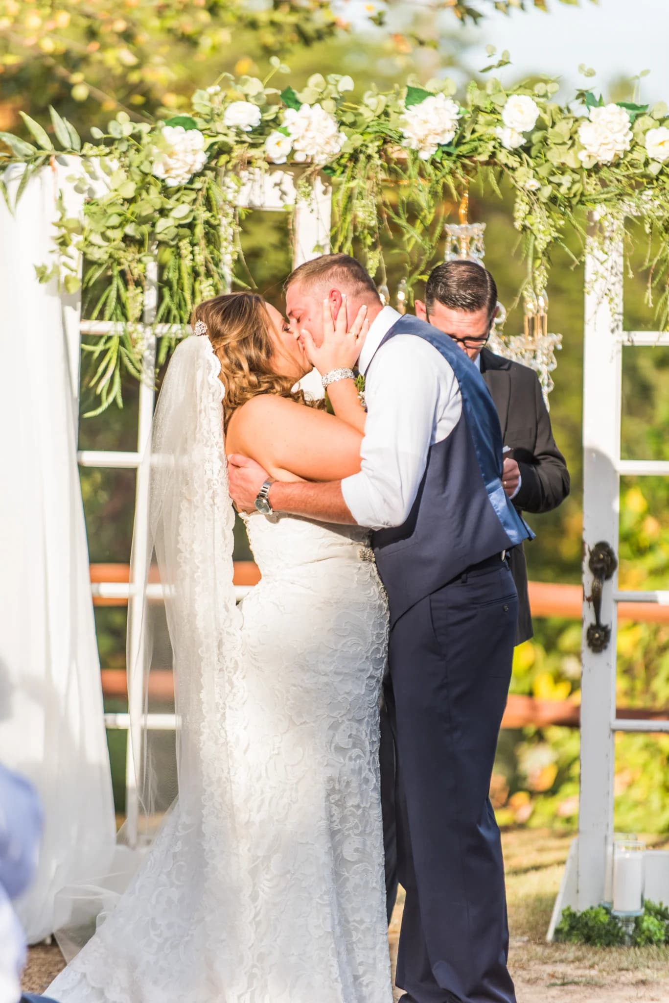 Bride and groom kiss under floral arch at outdoor ceremony in the Smoky Mountains at Moose Hollow Lodge in Pigeon Forge