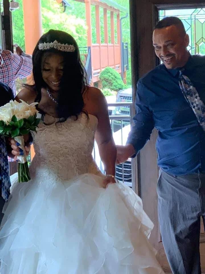 Bride in white wedding gown with bouquet entering venue at Moose Hollow Lodge in Pigeon Forge