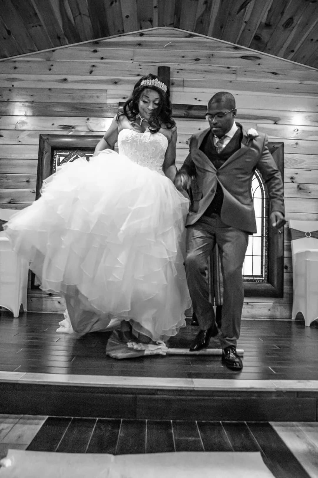 Wedding couple jumping the broom in rustic wood chapel at Moose Hollow Lodge in Pigeon Forge
