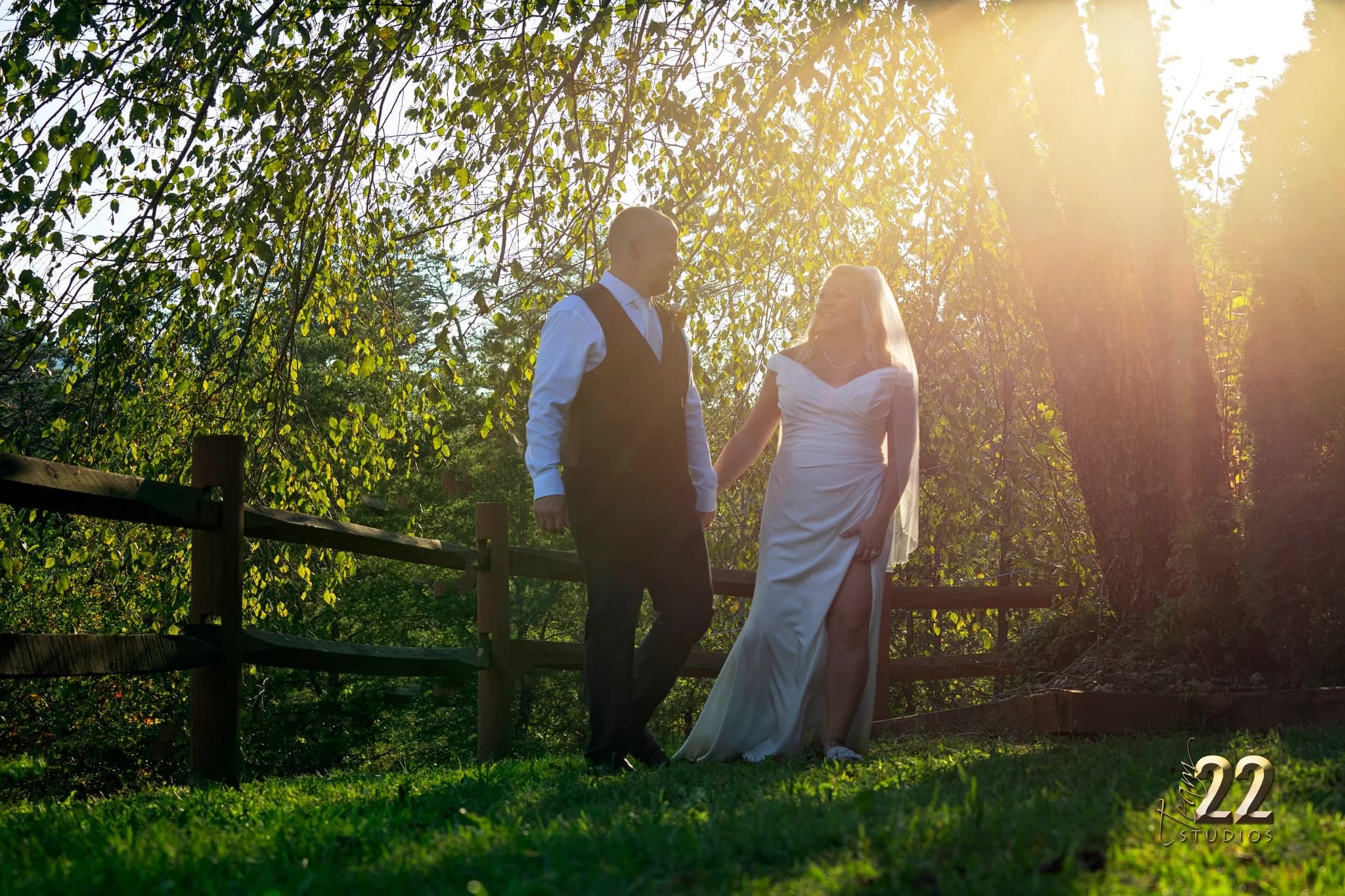 Bride and groom walk in sunlit outdoor garden at Moose Hollow Lodge in Pigeon Forge near Smoky Mountains.
